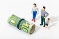 Human representation of a family looking at a Roll of money Royalty Free Stock Photo