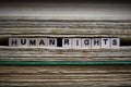Human rights restriction concept: Closeup of isolated antique old book pile text blocks and yellowed pages with wooden alphabet Royalty Free Stock Photo