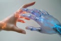 Human and robotic hands connect with glowing light in futuristic technology interaction