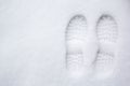 Human`s footprint on a first white snow, top view