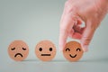 Human`s hand holding happy smile face on brown paper cut, satisfaction survey ,good feedback rating