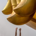 Human`s hands are stretched to a big buddha fingers at Wat muang Ang Thong province. Distance between peoples and gods