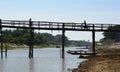 Human silhouettes on wooden bridge. Waw. Bago region. Myanmar