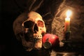 Human skull with vintage pocket clock, red heart and candle light on black fabric background , Love and time concept in still life