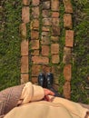 A human stands on the grass breaking through the stones