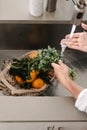 Human is washing local fruits and vegetables. From the farmers market. Zero waste. Net cotton organic shopping bag. Metal sink,