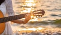 the human who playing guitar on the beach at sunset Royalty Free Stock Photo