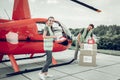 Humanitarian workers standing near helicopter sending parcels Royalty Free Stock Photo