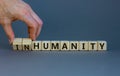 Humanity or inhumanity symbol. Businessman turns wooden cubes changes the word inhumanity to humanity. Beautiful grey table grey Royalty Free Stock Photo