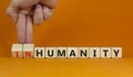 Humanity or inhumanity symbol. Businessman turns wooden cubes changes the word inhumanity to humanity. Beautiful orange table Royalty Free Stock Photo