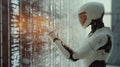 A humanoid robot interacts with a digital interface filled with data in a futuristic technology setting Royalty Free Stock Photo