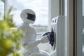 Humanoid robot loading clothes into washing machine Royalty Free Stock Photo