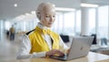 Advanced Humanoid AI Robot Working on a Laptop in a Modern Office Environment Royalty Free Stock Photo
