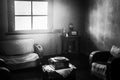 View into fifties style living room with sofa, armchair, table with vintage record player, sun light from window