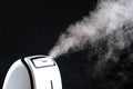 Humidifier with steam jet on a black background. Humidity in the room, maintaining the microclimate in the apartment.