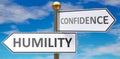 Humility and confidence as different choices in life - pictured as words Humility, confidence on road signs pointing at opposite Royalty Free Stock Photo