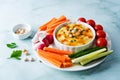 Hummus appetizer with carrot, radish, tomato and cucumber