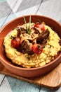 Hummus with beef served in brown bowl