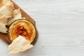 Hummus in bowl with roasted chickpeas, paprika, olive oil and pita bread on rustic wooden board over white wooden background, top Royalty Free Stock Photo