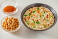 Hummus with chickpeas, oil, spices and herbs in bowl on white table, selective focus Royalty Free Stock Photo