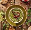 Hummus. Herbal hummus with the addition of pomegranate seeds, parsley, olive oil and aromatic spices in a ceramic pot on a wooden Royalty Free Stock Photo