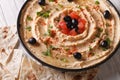 Hummus with olives, tomatoes and herbs close-up. Horizontal Royalty Free Stock Photo