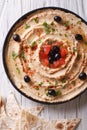 Hummus with olives, tomatoes and herbs vertical top view Royalty Free Stock Photo