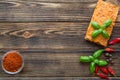 Hummus with sweet paprika and basil leaves on brown table, space for text Royalty Free Stock Photo