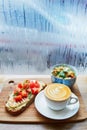 Hummus and tomato sandwich, salad and fresh hot cappuccino coffee