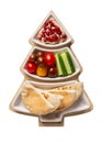 Hummus with vegetables and pita served on Christmas tree plate isolated on white background. Festive holiday snack. Top view