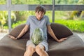 A humorous image: a pregnant woman and her husband playfully use a watermelon in place of a belly, comically Royalty Free Stock Photo