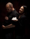 Humorous Mixed Race Couple Holding New White Baby Shoes on Black