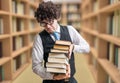 Humorous nerd professor with many books in library Royalty Free Stock Photo