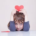 Humorous photo of cute little child girl having fun with red heart as symbol of love and amorousness