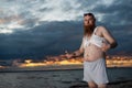 Humorous portrait of a brutal man posing on the beach at sunset Royalty Free Stock Photo