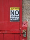 A humorous safety sign saying `Warning! No stupid people beyond this point`.