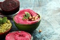 Humus Bowl. Red beetroot humus with fresh vegetables, healthy vegetable dip on background