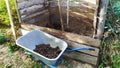 Humus. Cleaning humus in the garden. Transport manure in a garden trolley to the compost heap Royalty Free Stock Photo