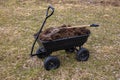 humus in a four-wheeled garden cart. Cloudy spring day