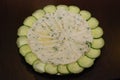 Humus served with cucumber slices on white plate