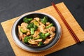 Hunan Chicken in black bowl at dark slate background. Chinese or indo-chinese cuisine takeaway dish Royalty Free Stock Photo