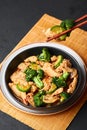 Hunan Chicken in black bowl at dark slate background. Chinese or indo-chinese cuisine takeaway dish Royalty Free Stock Photo