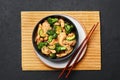 Hunan Chicken in black bowl at dark slate background. Chinese or indo-chinese cuisine takeaway dish Royalty Free Stock Photo