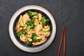 Hunan Chicken in black bowl at dark slate background. Chinese or indo-chinese cuisine takeaway dish