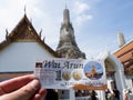 Hundred Baht entrance ticket with the Wat Arun Temple in the background in Bangkok, Thailand