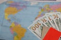 Hundred dollar banknotes. Bank cards. Against the background of a world map. Silhouettes of continents are visible on it