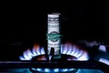 A hundred dollar bill on a gas burner with a burning fire on a black background, the front and back background is blurred with a Royalty Free Stock Photo