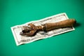 A hundred dollar bill and an old rusty can opener. Green background. Stash concept Royalty Free Stock Photo