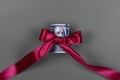 Hundred dollar bill tied with red bow on grey background. Money, gift wrapped in red bow and ribbon, US currency, cash, business