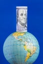 A hundred-dollar bill on top of the globe Royalty Free Stock Photo